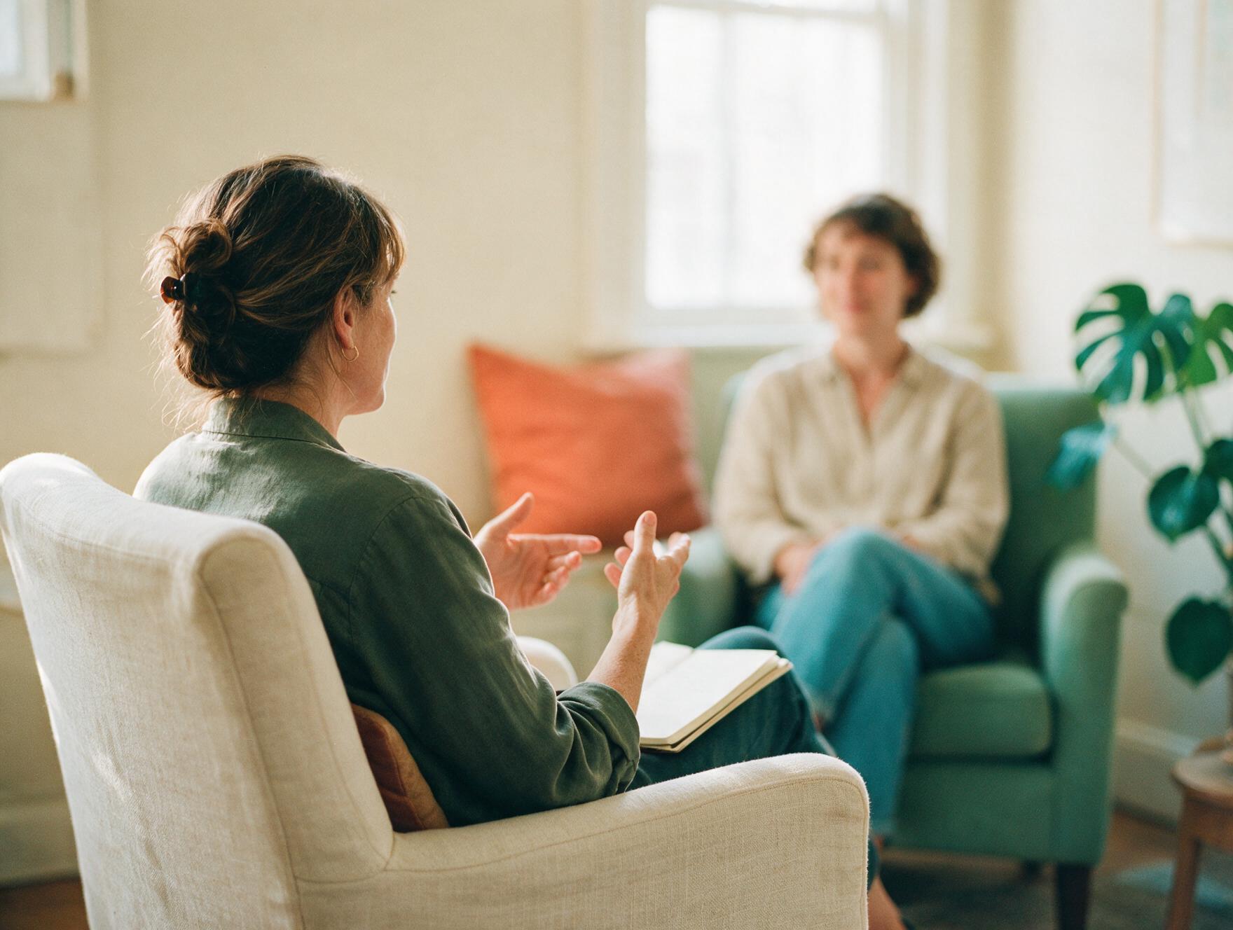 Une thérapeute en séance avec une cliente, dans un cabinet chaleureux